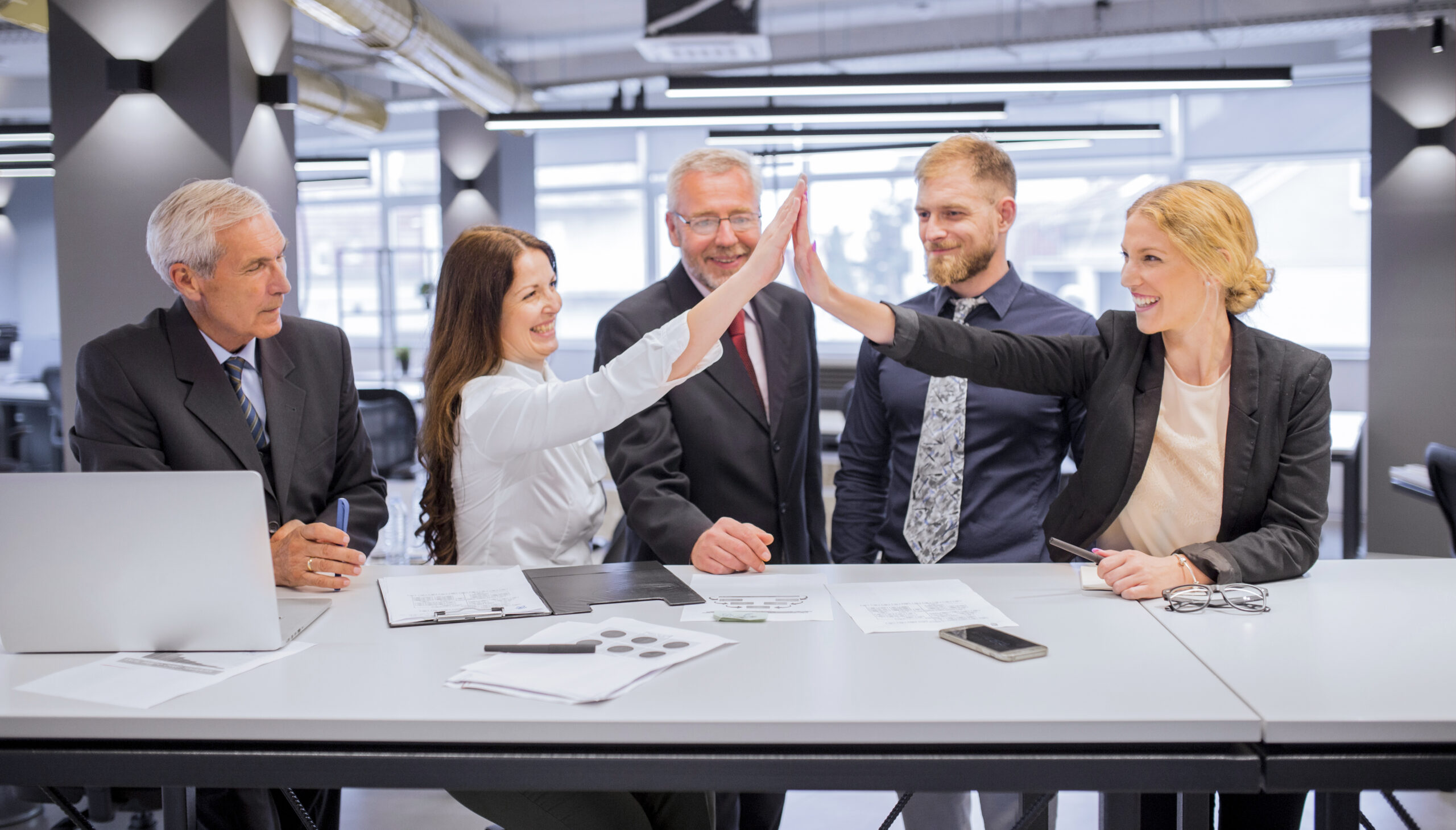 smiling-two-young-women-giving-each-other-high-five-office smiling-two-young-women-giving-each-other-high-five-office